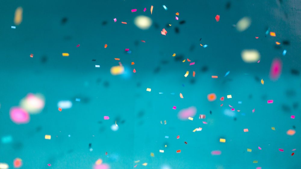 Confetti mixed colors on teal colored background